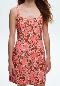 Brown sleeveless dress with a square neckline, featuring pink floral patterns outlined in white. Smooth fabric texture with a fitted silhouette.