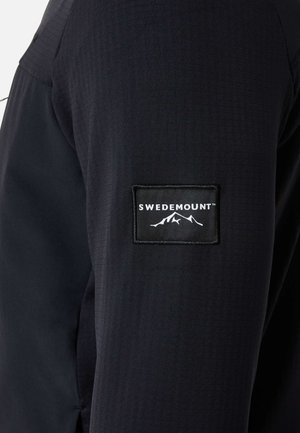 Czarna rękaw z prostokątną naszywką z logo Swedemount, zawierającą biały tekst i grafikę góry.