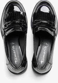 Mocassins en cuir verni noir avec des détails à franges plissées et des accents métalliques. Doublure intérieure rembourrée et semelle texturée pour plus de confort.
