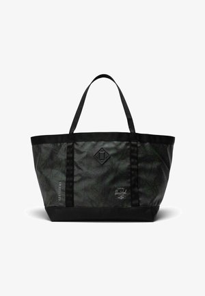 Sac fourre-tout Herschel à motif camouflage noir et vert foncé, avec deux poignées, patch logo et dimensions imprimées sur le côté.