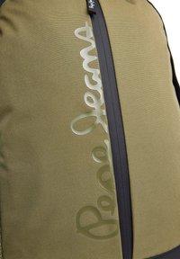 Olivgrön tygryggsäck med en svart dragkedja och en framträdande, glänsande "Pepe Jeans"-logotyp. Texturerad yta med släta accenter.