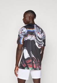 Camicia da uomo a maniche corte nera, con un motivo astratto lucido dai colori vivaci e una texture liscia e sintetica.