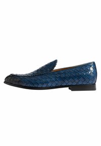 Mocasines de cuero tejido en azul con un diseño elegante, que cuentan con una punta afilada y un bajo tacón negro. Superficie texturizada con patrones intrincados.
