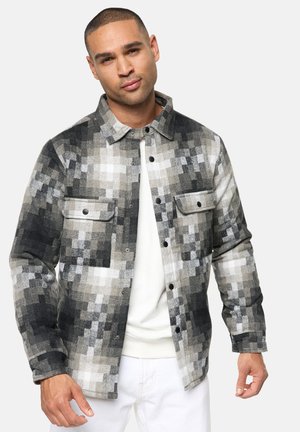 Plaid jacket with black, gray, and white blocks. Features button front, two chest pockets, and a collar. Textured fabric with a subtle sheen.