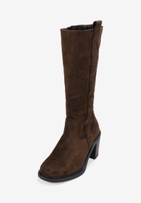 Stivale al ginocchio in suede marrone con tacco a blocco, texture liscia, punta arrotondata e dettaglio delle cuciture laterali. L'interno presenta una fodera nera.
