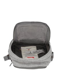 Grijze voelbare tas met een ritsopening, interieur van een donkerder stof, met een label met branding en onderhoudsinstructies.