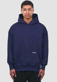Sweat-shirt à capuche bleu marine en coton, doté d'une poche avant, de poignets côtelés et d'un accent logo argenté sur la poche.