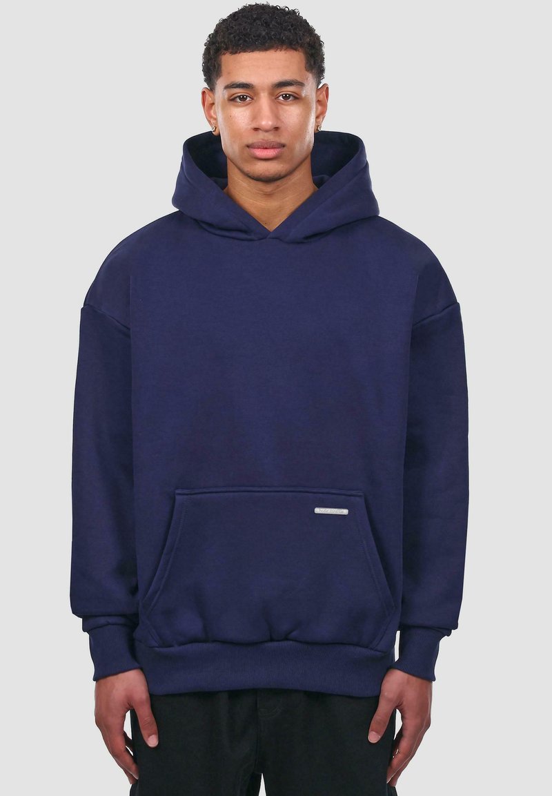Sweat-shirt à capuche bleu marine en coton, doté d'une poche avant, de poignets côtelés et d'un accent logo argenté sur la poche.
