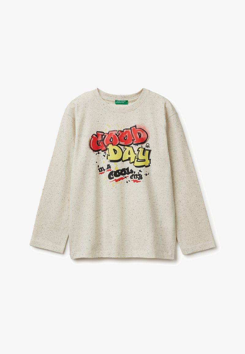 Camisa de manga larga de un beige claro con textura moteada. Presenta un gráfico colorido que dice "BUEN DÍA en una ciudad genial" en rojo, amarillo y negro.