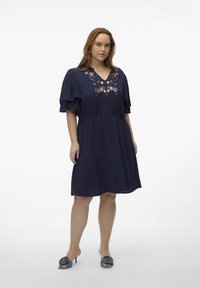 Vestido azul marino oscuro con mangas cortas en capas, escote en forma de V y bordado floral colorido en el pecho. Tejido suave, de longitud por encima de la rodilla.