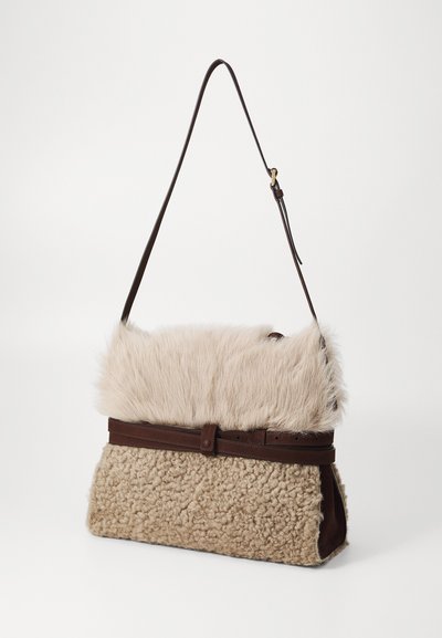 Sac en fausse fourrure beige avec un rabat supérieur en peluche, un corps en shearling texturé et une sangle et des accents en cuir marron. Comprend une fermeture magnétique.