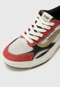 Vans tenisice s gornjim dijelom od crvene antilop kože i bež tkanine, bijelim vezicama, mrežastim dijelovima i crno-bijelim gumeni potplat.