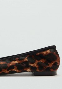 Chaussure plate à imprimé léopard avec un tissu doux et texturé, des finitions noires, un petit talon et une conception à bout rond.