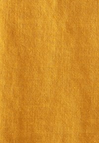 Tessuto strutturato in una vivace tonalità gialla senape, con una finitura intrecciata e naturale, caratterizzato da fibre visibili e una superficie leggermente ruvida.