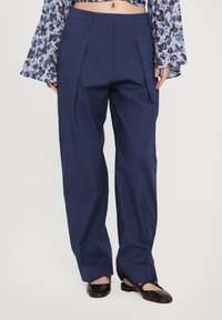 Navy blue pleated trousers made of smooth fabric with a straight leg design. Features a mid-rise waistband and belt loops.