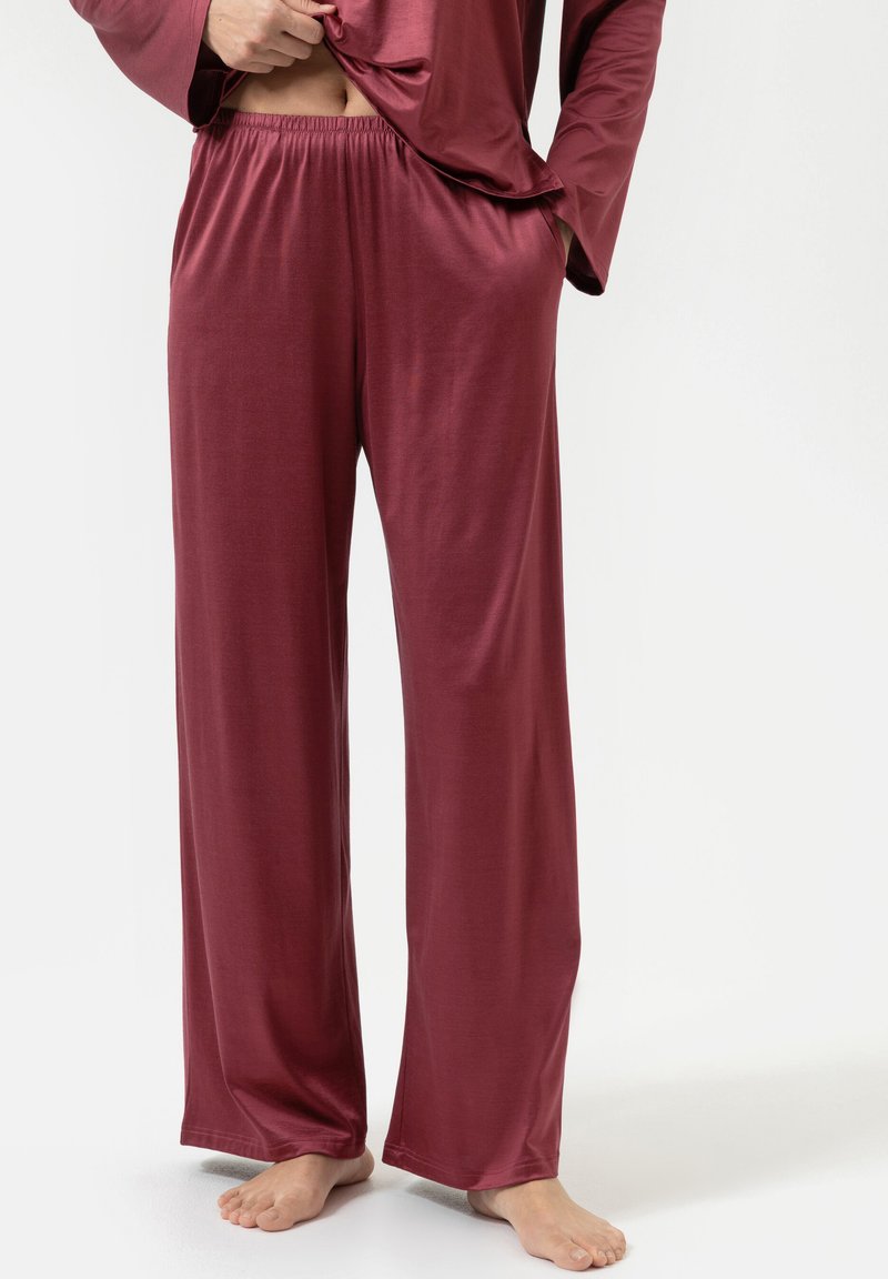 Bordeaux loungebroeken van zacht, glad stof. Voorzien van een elastische tailleband en losse, rechte pijpen. Geen zichtbare patronen of accenten.