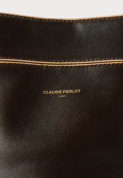 Črna usnjena površina z gladko teksturo, z vidno šivno črto in zlato odtisnjeno logotipom: "CLAUDIE PIERLOT PARIS."