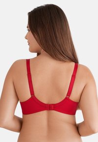 Rode beha met verstelbare bandjes, een gladde textuur en een haak-en-oogsluiting. Bevat gegolfde details langs de rand.