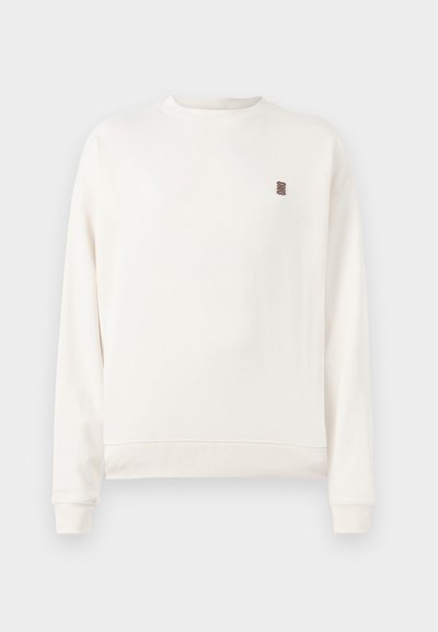 Hvid langærmet sweatshirt med rund hals og lille mørk logo på venstre bryst, ribbede manchetter og kant, præsenteret på lys baggrund.