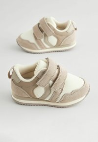 Beżowe i kremowe sneakersy z rzepami, wykonane z siateczki i zamszu, o zaokrąglonym kształcie, z teksturowaną podeszwą i kontrastowymi panelami bocznymi.
