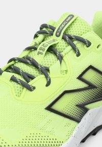 Neon yellow running shoe with mesh upper, black accents, grey laces, and textured sole. Features branding on tongue and side.