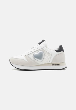 Sneakers bianchi realizzati in suede e mesh. Presentano un design a forma di cuore e il marchio "LOVE MOSCHINO" sul lato. Dettagli neri sul tallone.