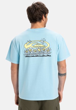 Light blue cotton t-shirt featuring a graphic of smiling flowers with stars and a mountain integrated into an outline in yellow and black.