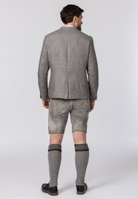 Gray linen blazer with notch lapels, paired with light gray shorts. Worn with knee-high cable knit socks and black shoes.