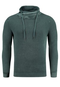 Textuur groene trui met een kraag, voorzien van een gebreid patroon, lange mouwen en ribbels aan de onderkant. Trekkoorden accentueren de hals.