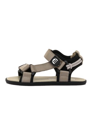 Sandaletto aperto da esterno con cinturini beige regolabili, suola nera, plantare imbottito e piccolo logo tondo nero sulla cinghia alla caviglia.