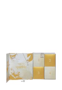 Scatola per gioielli con un design floreale in crema e oro. Espone un set di collana e orecchini, con dettagli in argento e accenti di perle.