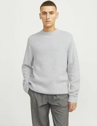 Grauer gestrickter Pullover mit Rundhalsausschnitt und langen Ärmeln, kombiniert mit grauen Hosen. Glatte Textur, minimalistisches Design ohne sichtbar Muster.