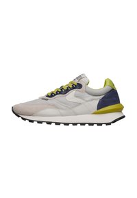 Sneakers con una combinazione di pelle beige e camoscio, accenti blu scuro, lacci verde brillante e una suola in gomma nera; design retrò e tallone imbottito.