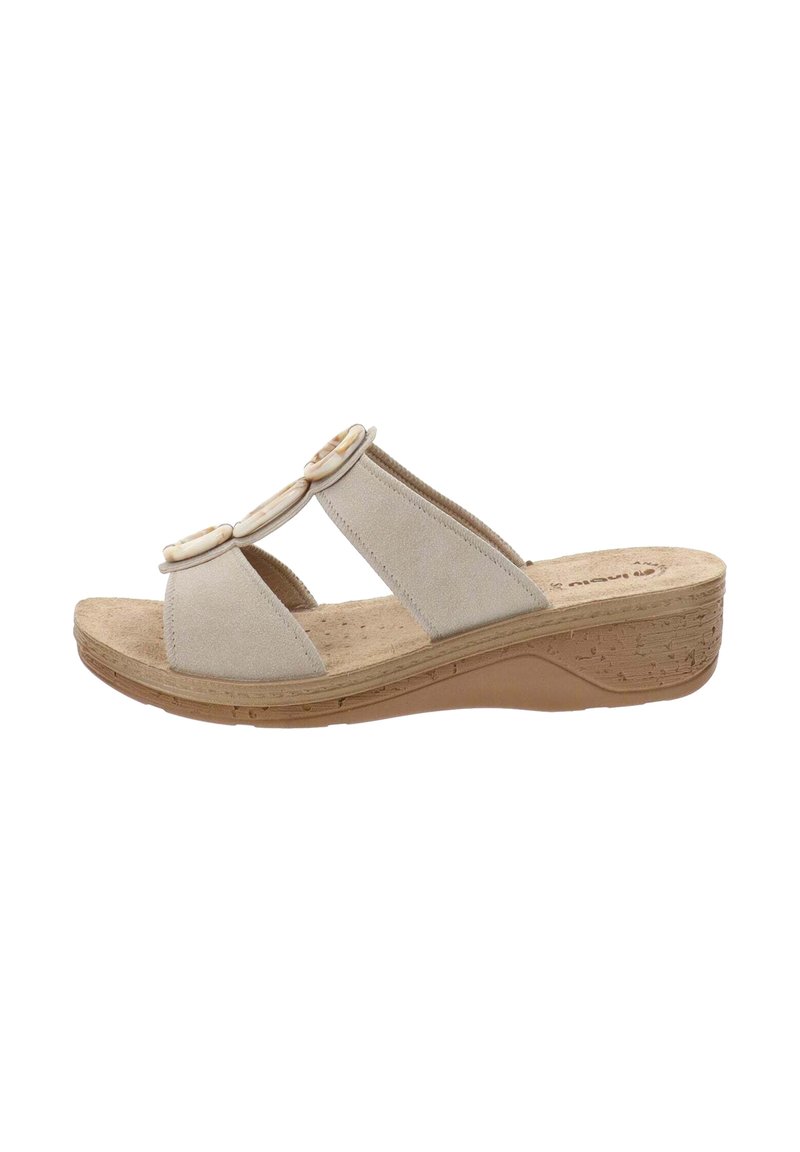 Sandali slide in suede beige con ritagli laterali e due dettagli circolari sulle cinghie. Suola a zeppa con texture in sughero per un supporto aggiuntivo.