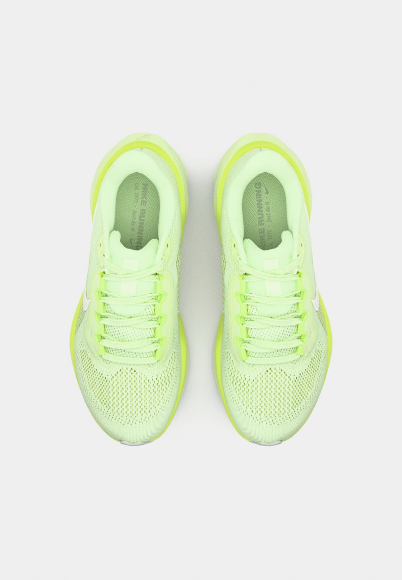 Zapatillas de correr verde claro con parte superior de malla, cordones planos y suela acolchada con un acento reflectante a lo largo del lado.