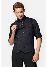 Czarna kamizelka dwurzędowa z teksturowanej tkaniny, z dwoma przednimi kieszeniami i detalami w postaci guzików, połączona z dopasowaną czarną koszulą.