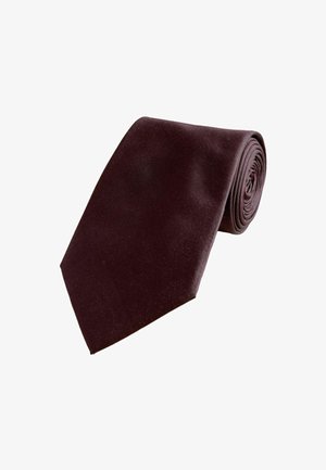 Cravate texturée brun foncé roulée avec une pointe effilée sur un fond blanc.