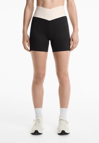 Crne kratke hlače viskog struka s pojasom od kremaste boje s teksturom, uz elegantan dizajn i prilagođen siluetu, prikladne za sportske aktivnosti.