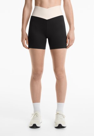 Hoge zwarte shorts met een crèmekleurige, gestructureerde tailleband, met een slank ontwerp en een getailleerde pasvorm, geschikt voor sportkleding.