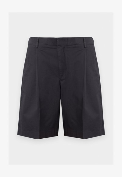 Shorts noirs ajustés longueur genou avec passants de ceinture et plis avant sur un fond gris clair uni.