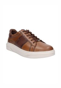 Zapatilla de cuero marrón con un panel texturizado, suela de goma crema y cordones a juego. Punta redondeada y elementos de diseño minimalistas.