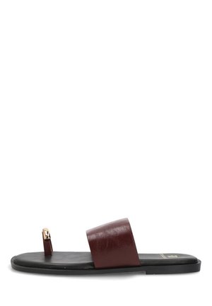 Sandalia plana negra con una ancha tira de cuero marrón oscuro y una pequeña tira para el dedo del pie con un detalle de hebilla en tono dorado.