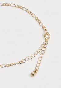 Gouden ketting met een mix van schakels en een kreeftsluiting, voorzien van een verstelbare extenderketting die eindigt in een klein rond bedeltje.