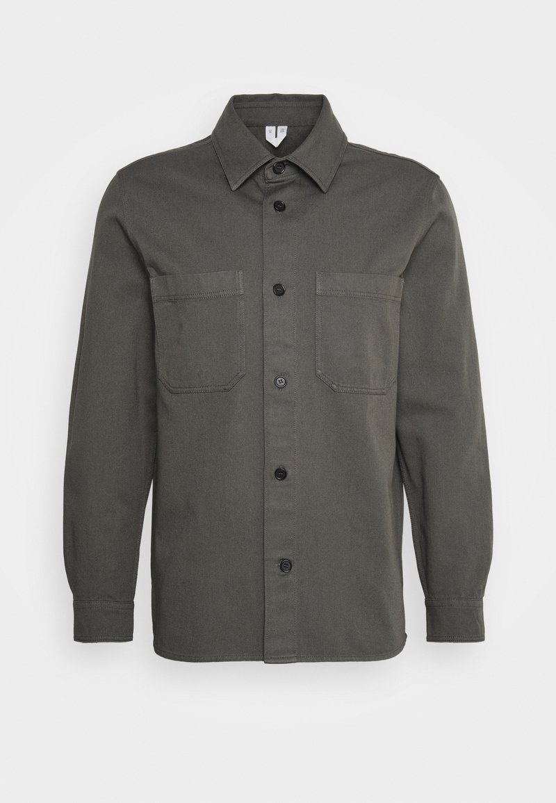 Donkergroen shirt met lange mouwen, knoopsluiting aan de voorkant, twee borstzakken, een puntige kraag en een rechte zoom. Gelaagd stof.