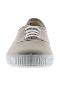 Baskets en toile beige clair avec semelle et lacets en caoutchouc blanc. Présente une texture lisse et un design minimaliste.