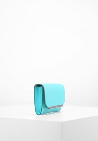 Turkusowa kopertówka o teksturowanym wykończeniu, prostokątnym kształcie, z zamknięciem na klapę oraz srebrzystymi akcentami na przodzie.