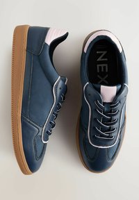 Marina lädersneakers med vita detaljer, strukturerad yta och kontrasterande gummisula. Har sex hål och vadderad krage.
