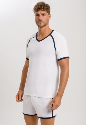 Hvid kortærmet V-hals top og matchende shorts med marineblå detaljer og kant. Blødt stof, afslappet pasform, enkelt design.