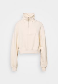 Sudadera recortada en color crema, con cuello alto, cierre de media cremallera y mangas voluminosas. Textura suave con un dobladillo ajustado.