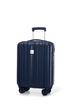 Navy hard-shell suitcase with vertical grooves, four wheels, retractable handle, and a silver logo plate. Features sturdy zippers and accents.